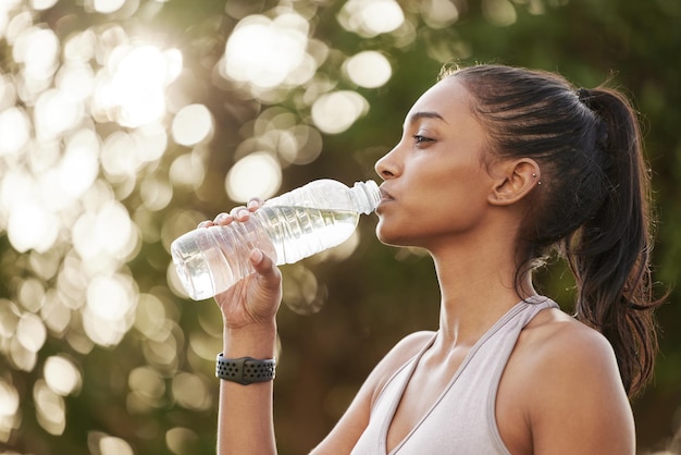 Neem pauzes wanneer u uw energie moet aanvullen. Shot van een sportieve jonge vrouw die water drinkt tijdens het sporten buitenshuis.