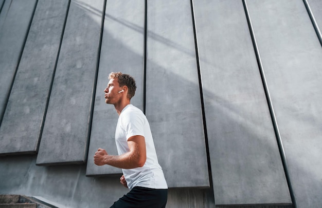 Neemt een pauze Jonge man in sportieve kleding traint overdag buiten