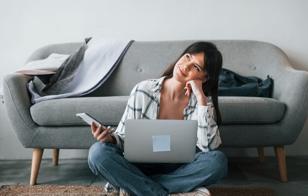 Neemt een pauze Jonge vrouwelijke freelance werknemer is overdag binnenshuis in huis