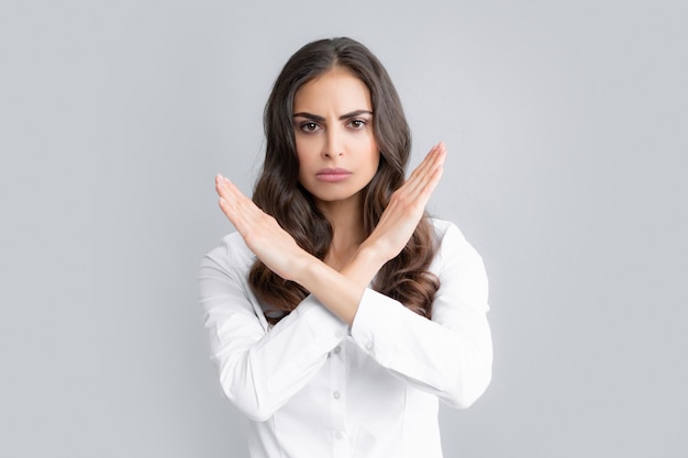 Negatieve vrouw gekruiste handen tonen geen achteruitgang verboden regel geïsoleerd over grijze achtergrond