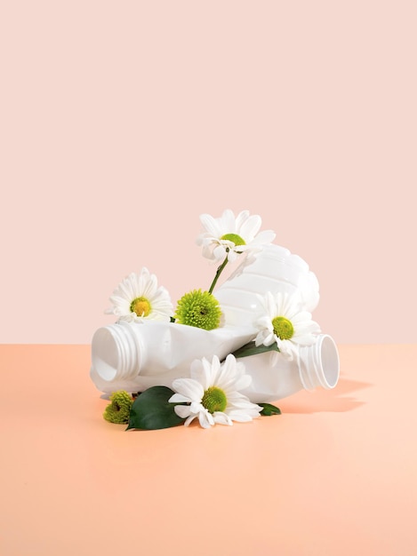 Photo negative impact on nature plastic bottles crush beautiful flowers on a peachcolored background soil pollution the idea of plastic pollution the concept of environmental damage