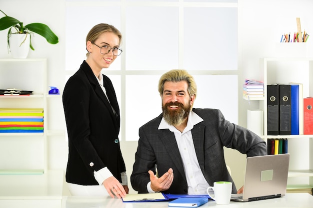 Foto in negoziazione. partnership di successo. uomo e donna di brainstorming in ufficio. concetto di collaborazione e team building. l'uomo d'affari e l'assistente alla segretaria guardano la documentazione. capo e dipendente.