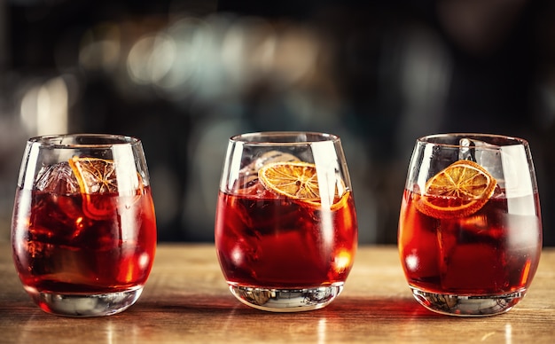 Negroni classic cocktail and gin short drink with sweet vermouth, red bitter liqueur and dried orange garnish.