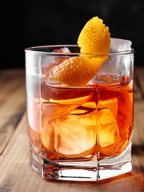 Negroni cocktail in a glass of rocks. Vertical photography.