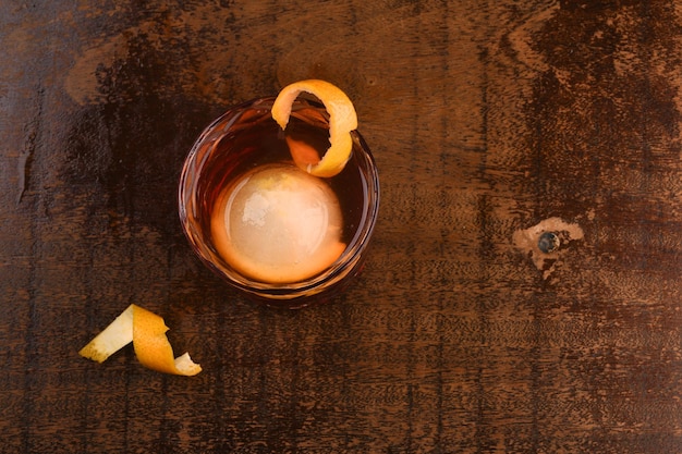 Negroni-cocktail met rond ijs op houten tafelbladweergave