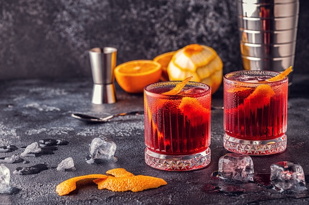 Negroni cocktail with orange peel and ice, selective focus.