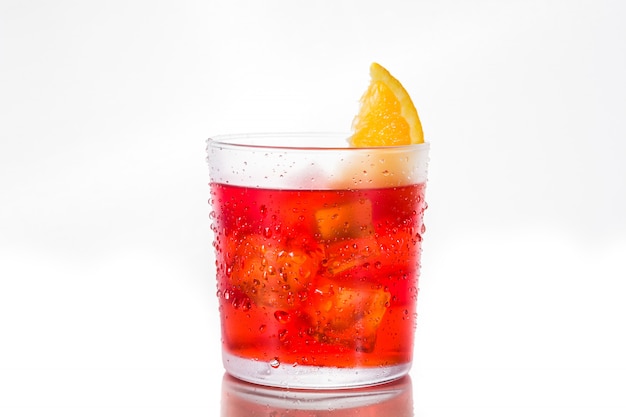 Negroni cocktail with piece of orange in glass isolated on white