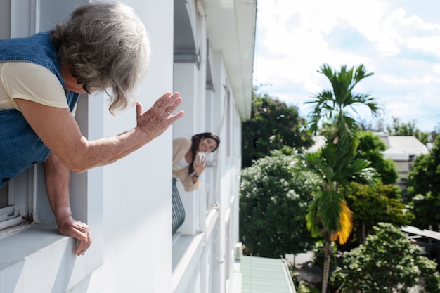 Photo neighbor women saluting eachother