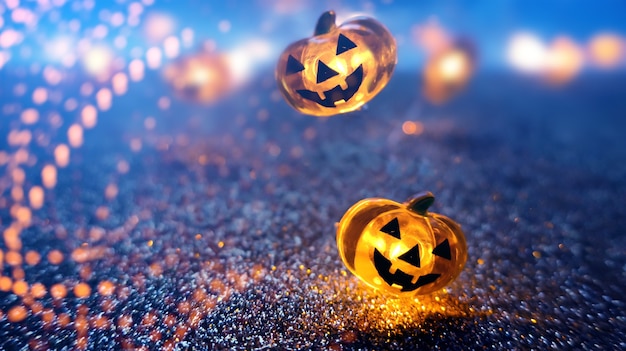 Testa di zucca incandescente al neon su sfondo bokeh sfocato astratto. priorità bassa festiva di halloween con ragnatele e zucca.