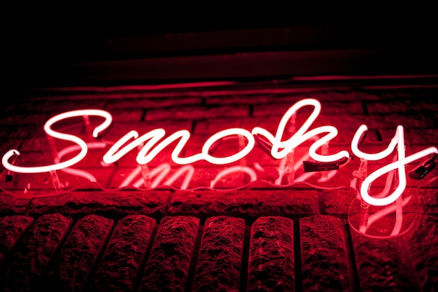 Neon inscriptie smoky op de muur veelkleurige neon inscriptie smoky op donkere achtergrond