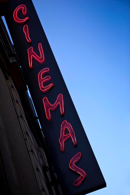 Photo neon sign of a movie theater in town