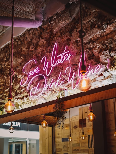 neon sign on a rustic stone wall