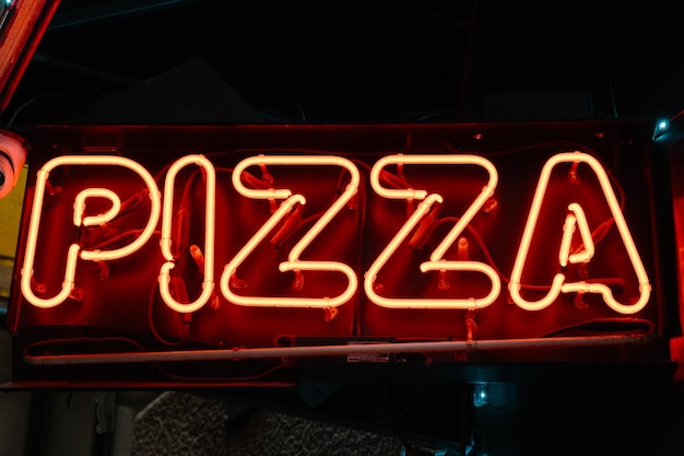 Neonbord met het woord pizza.