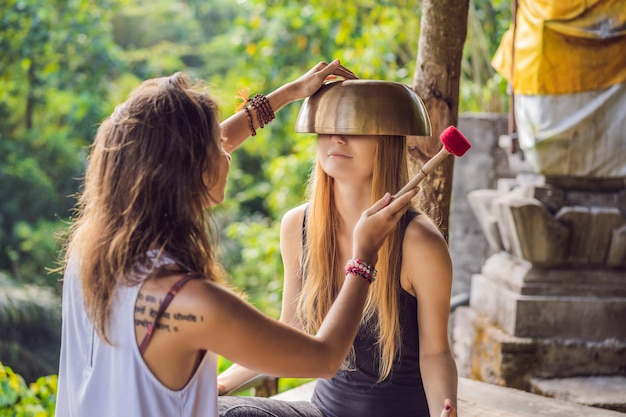 Nepal buddha copper singing bowl at spa salon young beautiful woman doing massage therapy singing