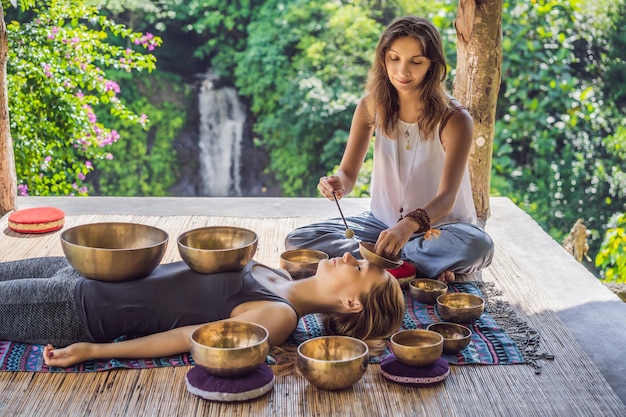 nepal buddha copper singing bowl at spa salon young beautiful woman doing massage therapy singing