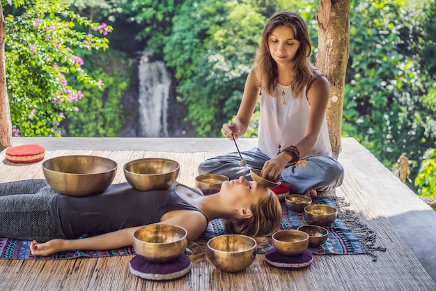 Nepal buddha copper singing bowl at spa salon young beautiful woman doing massage therapy singing