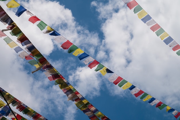 Foto bandiere del nepal su chiaro cielo blu con nubi cumuliformi per attrazione viaggio turistico