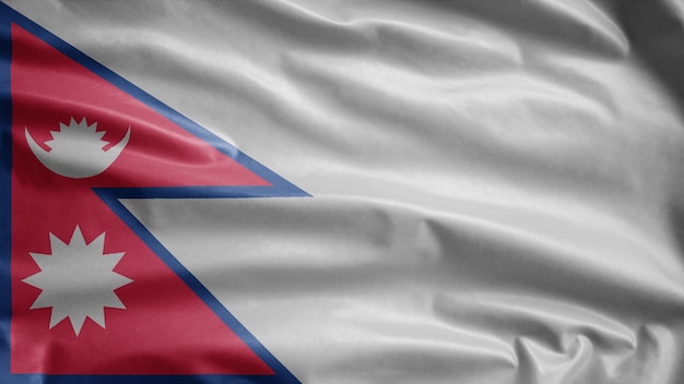 непальский флаг развевается на ветру. непальский баннер, мягкий и гладкий шелк