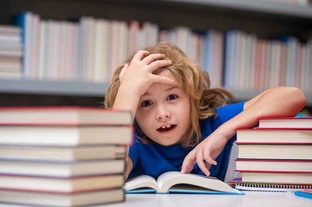 Nerd pupil school child pupil reading book at school kid doing homework sitting at table by books in