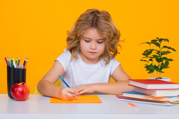 Nerd school kid isolated on studio background Clever child from elementary school with book Smart genius intelligence kid ready to learn Hard study