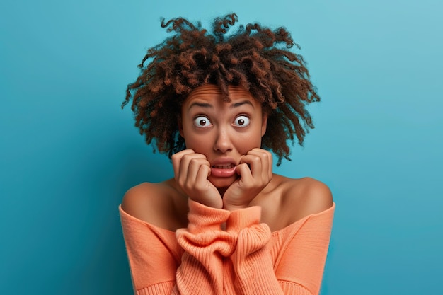 Nervous African American woman and biting nails in studio with oops reaction to gossip on blue