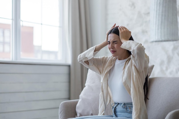 Depressione da esaurimento nervoso attacco di panico una giovane bella donna bruna si siede sul divano di casa