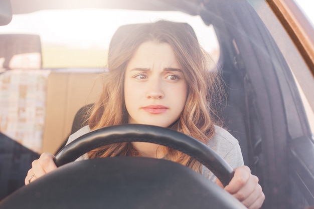 Nervous female driver sits at wheel