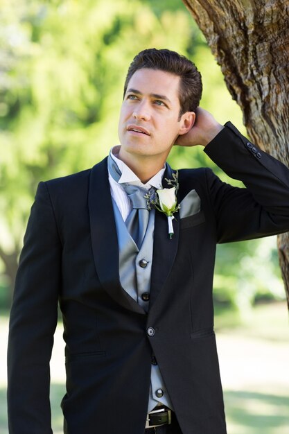 Nervous groom looking away at garden