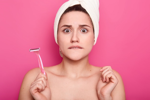 Photo nervous puzzled woman bites lower lip