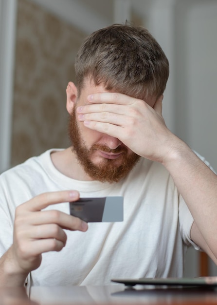 Nervous sad upset confused young man stressed worried guy having problem with paying buying online