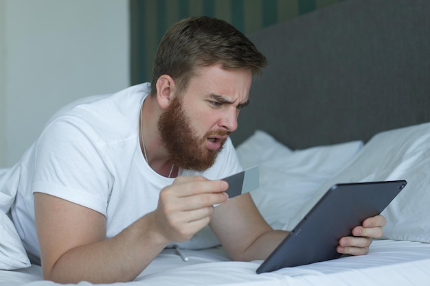 Nervous sad upset confused young man stressed worried guy having problem with paying buying online