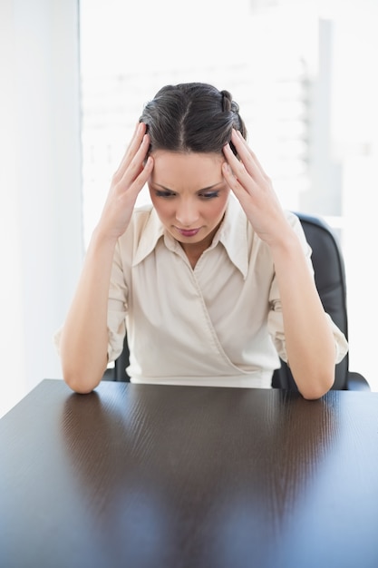 Nervous stylish brunette businesswoman holding her head