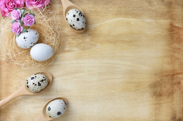 Nest eieren en bloemen op hout achtergrond.
