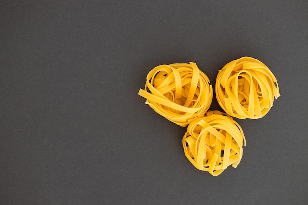 Nest of tagliatelle on black background