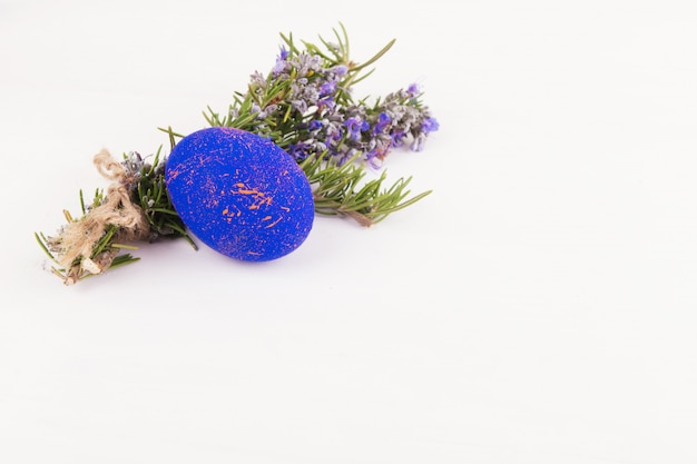 A nest with easter eggs and rosemary close up on a white background