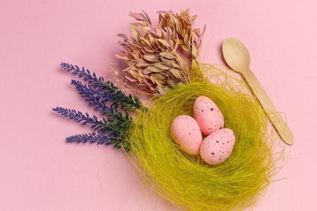 Nest with pink Easter eggs on the pink background