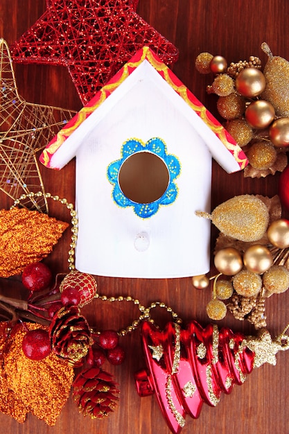 Nesting box and Christmas decorations on wooden background
