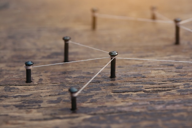 Net gemaakt door een draad tussen spijkers op een houten bord