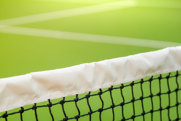 net of tennis with white stripe in green court