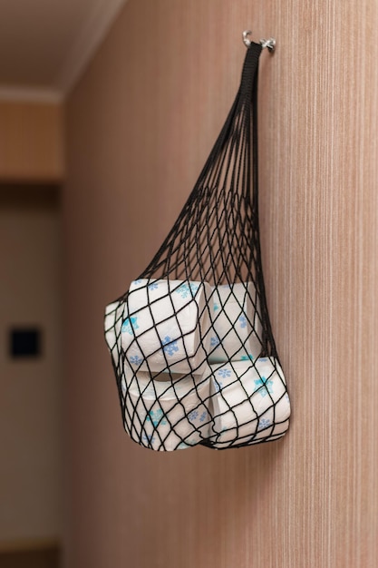 a net with toilet paper rolls hangs on the wall