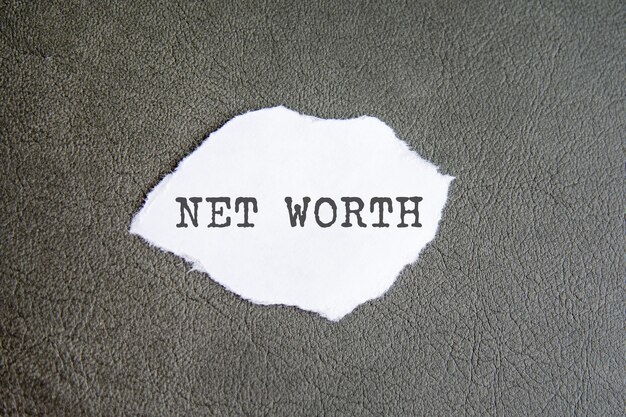 NET WORTH sign on the torn paper on the grey background