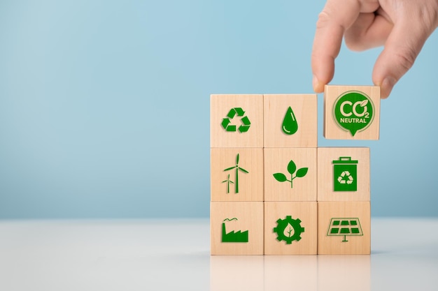 ネットゼロとカーボンニュートラルのコンセプトグリーンネットゼロのアイコンが付いた木製の立方体を置くCO2NetZero排出量カーボンニュートラルの概念再生可能エネルギーCO2排出量削減グリーン生産