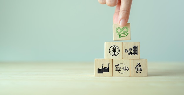 Net zero target and carbon neutral Green business concept Climate changing problems solving goalsStacking wooden cubes with net zero icon on pollution source icon on grey background and copy space