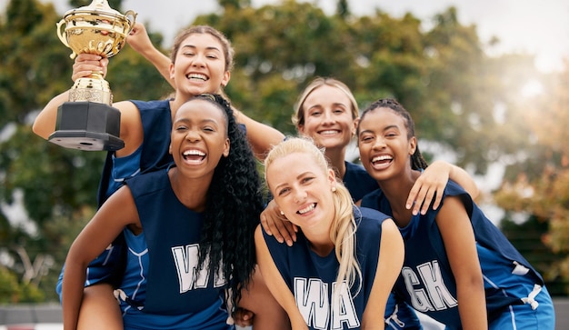 Netbalspel teamsporten en trofeewinnaar in sportcompetitie op rechtbanksamenwerking voor winnen en teamwerk voor succes in evenement Vrouwelijke atleet viert samen prijs en kampioensprestatie