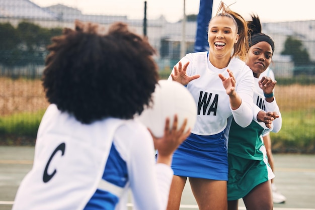 Netbalsport en vrouwen in een wedstrijd of spel die competitief zijn in een competitie op een baan als teamgenoten Fitness trainen en vrouwelijke atleten blij voor sporten en bewegen op de middelbare school als een team