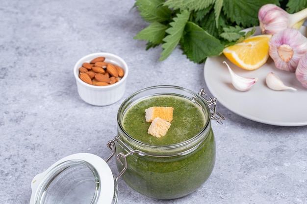 Nettle soup made from young shoot In a glass jar nettle garlic almond lemon juice oil croutons