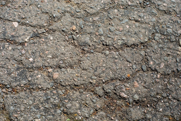 A network of black cracks on the asphalt surface Road texture with weathered surface showcasing the effects of time and wear