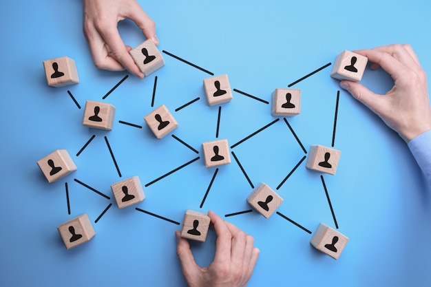 network community - man hands put the wooden bricks with person icon