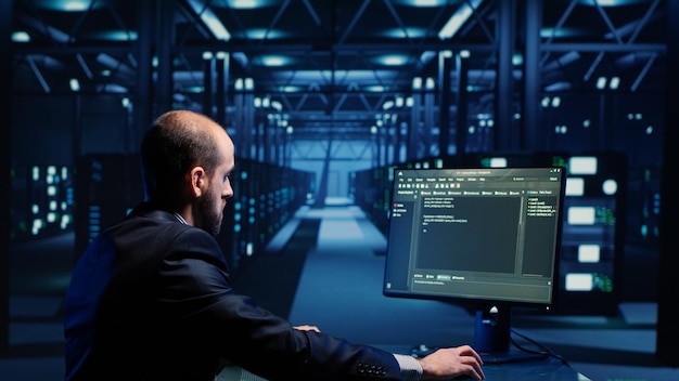 Network engineer doing hardware check on computer in server room, working with data protection for cyber security. Data center specialists inspecting system and hardware. Tripod shot.