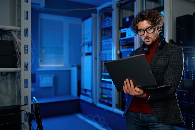 Network engineer using digital tablet in server room during maintenance work in data center with supercomputer. Technical support